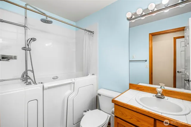 a bathroom with a sink vanity mirror and toilet