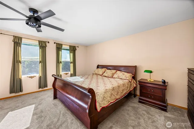 a bed sitting in a spacious bedroom next to a window
