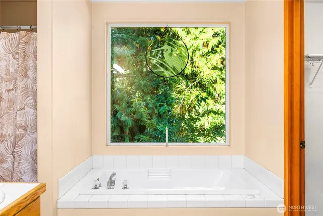 a bathroom with bathtub and window