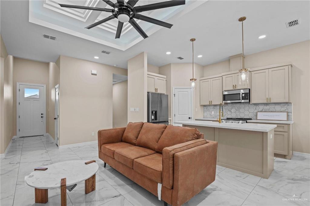 2700 East Conroe Road Edinburg, TX 78542 - Photo 5 of 16 a living room with stainless steel appliances kitchen island a chandelier
