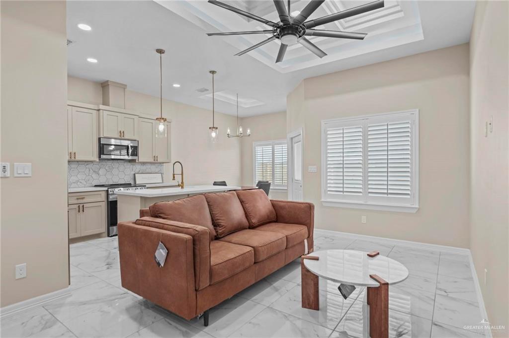 2700 East Conroe Road Edinburg, TX 78542 - Photo 6 of 16 a living room with stainless steel appliances kitchen island furniture and a chandelier