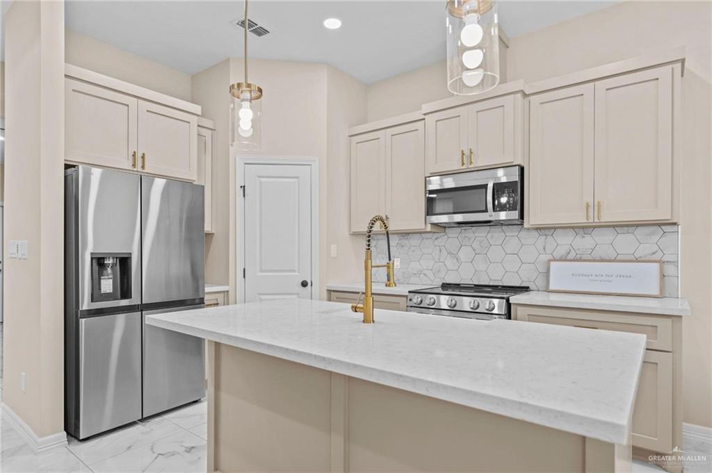 2700 East Conroe Road Edinburg, TX 78542 - Photo 8 of 16 a kitchen with stainless steel appliances a refrigerator sink and microwave