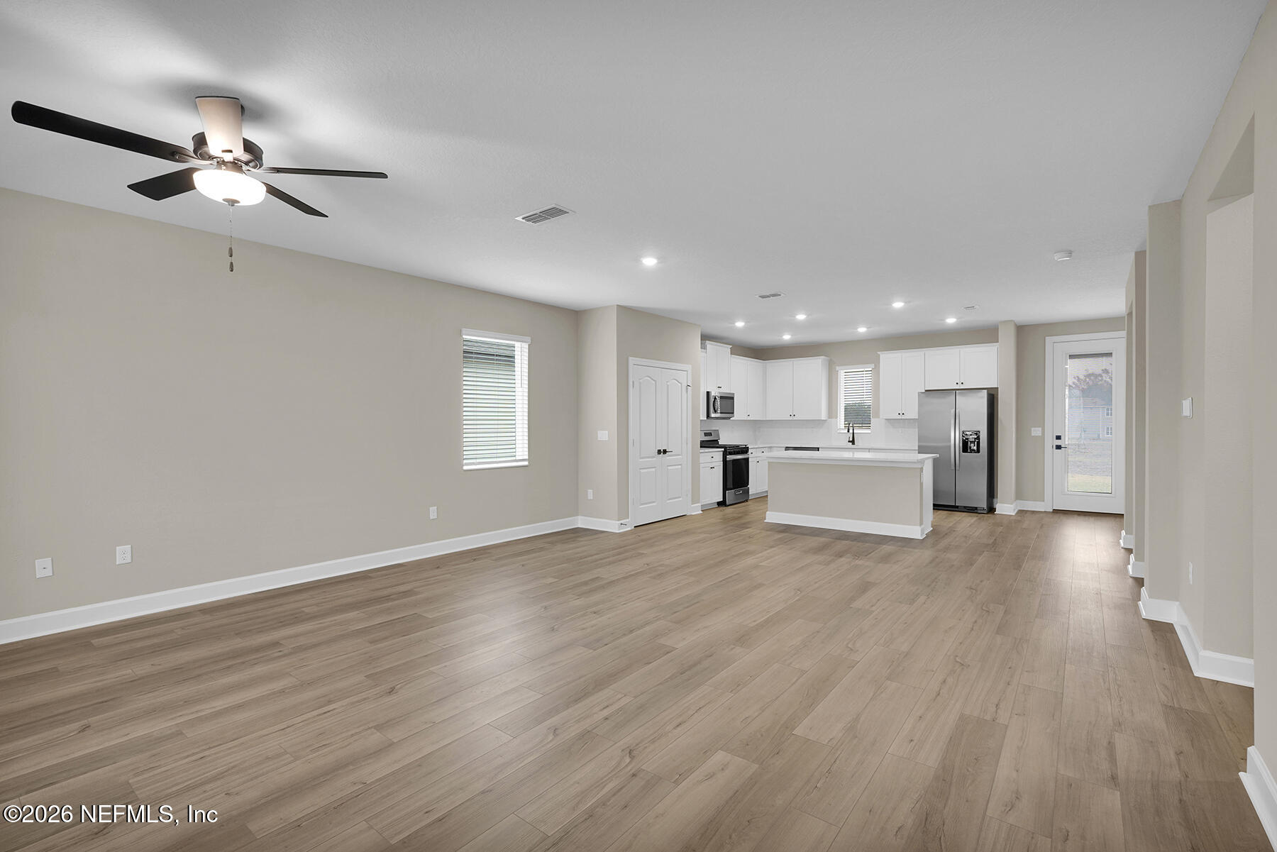 2416 Pemrose Loop Middleburg, FL 32068 - Photo 4 of 26 a view of an empty room with wooden floor and a kitchen