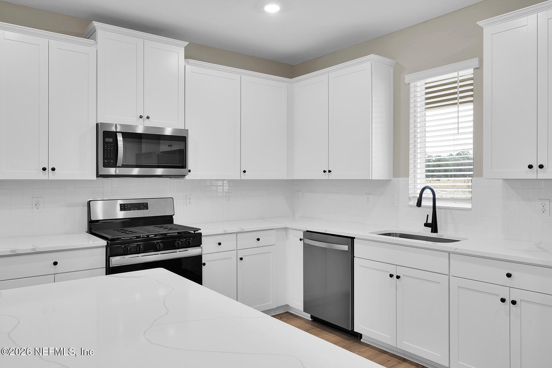 2416 Pemrose Loop Middleburg, FL 32068 - Photo 9 of 26 a kitchen with white cabinets appliances and a window