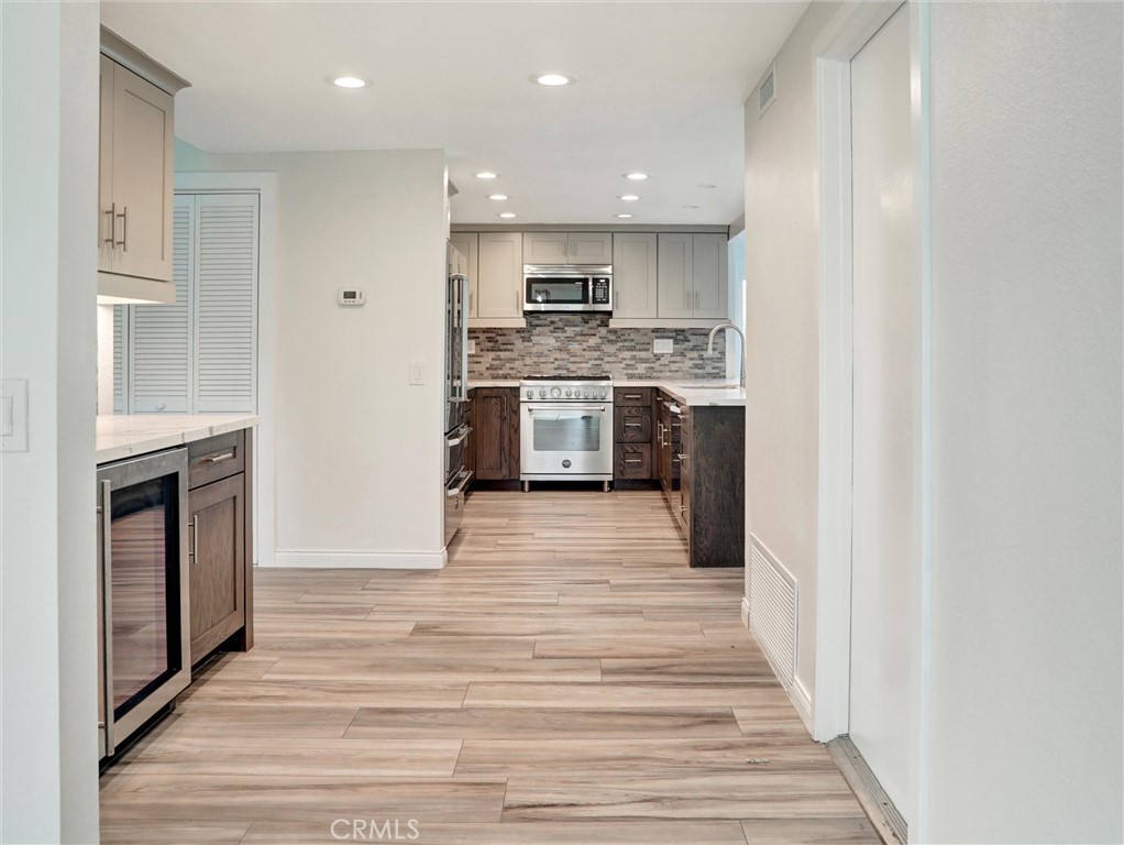 933 Carnation Avenue Costa Mesa, CA 92626 - Photo 24 of 33 a large kitchen with stainless steel appliances granite countertop a stove and a refrigerator
