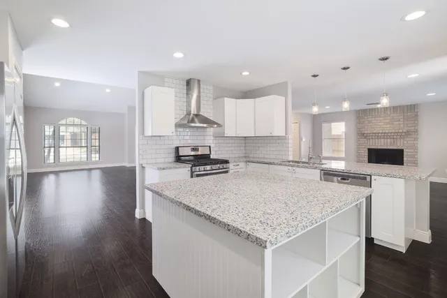 a kitchen with stainless steel appliances granite countertop a sink stove and a refrigerator