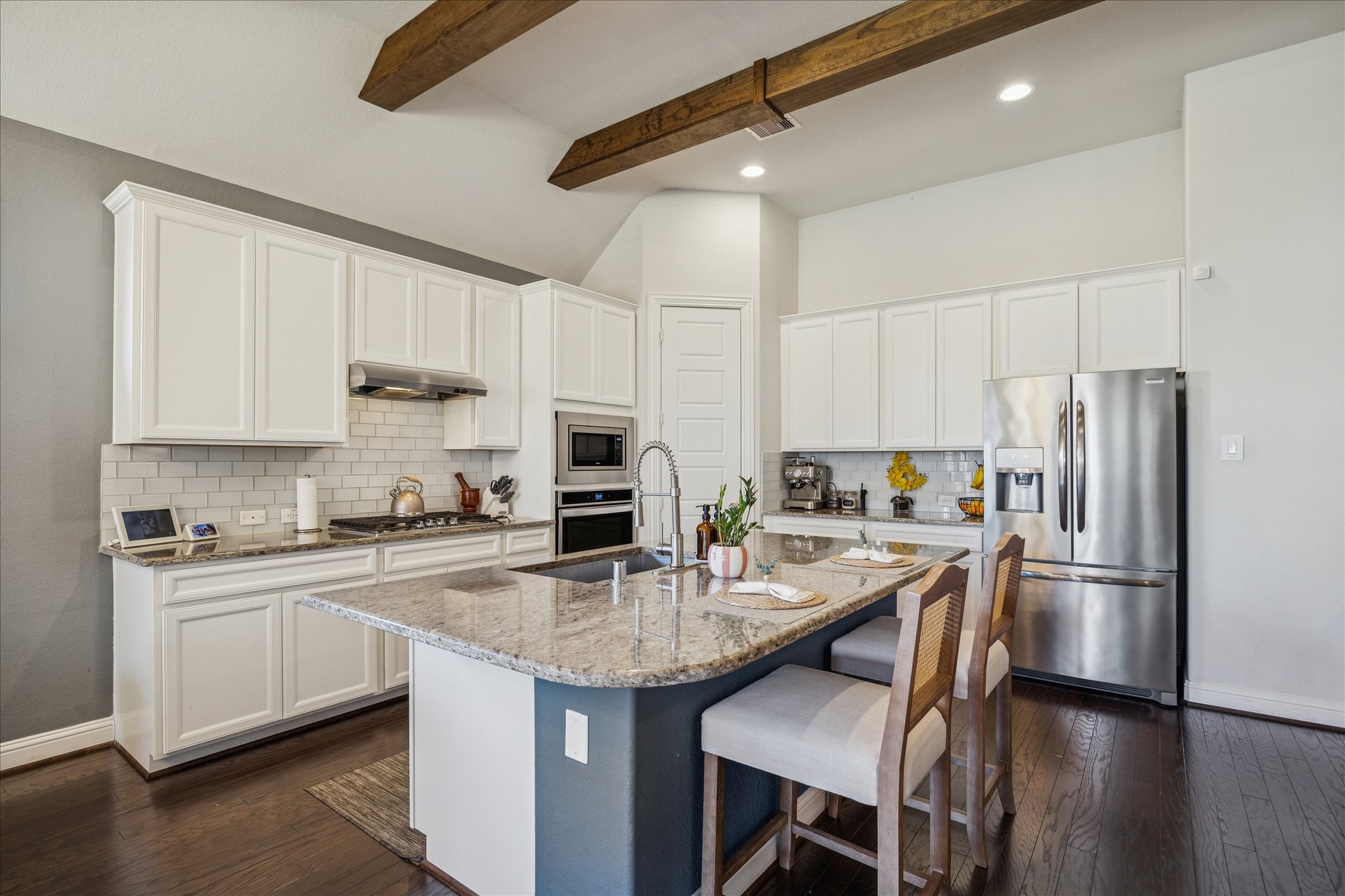 25214 Dewstone Way Porter, TX 77365 - Photo 10 of 29 Plenty of bar seating, gorgeous and timeless backsplash and painted cabinets give this kitchen a beautiful and functional space.