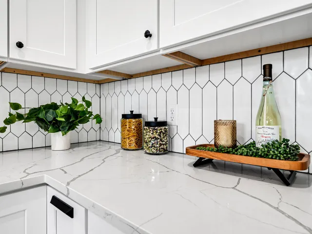 a kitchen with stainless steel appliances granite countertop a sink and a white wooden cabinets