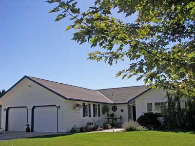 10542 Mieras Road Moxee, WA 98936 - Photo 1 of 29 a front view of a house with a garden and yard