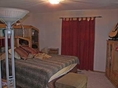 10542 Mieras Road Moxee, WA 98936 - Photo 9 of 29 a bed sitting in a bedroom next to a wooden door