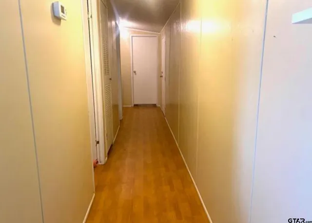 a view of a hallway with wooden floor