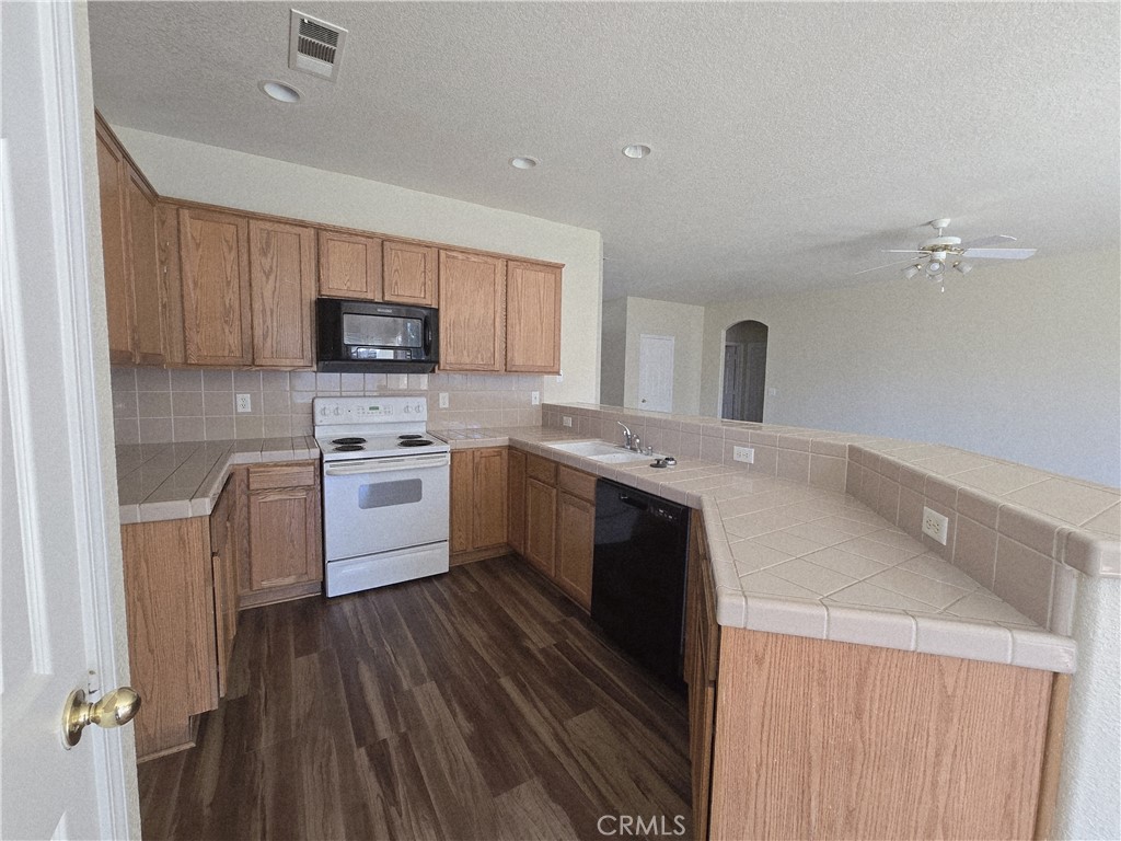 2656 Mira Court Merced, CA 95341 - Photo 5 of 23 a kitchen with a sink a counter top space stainless steel appliances and cabinets