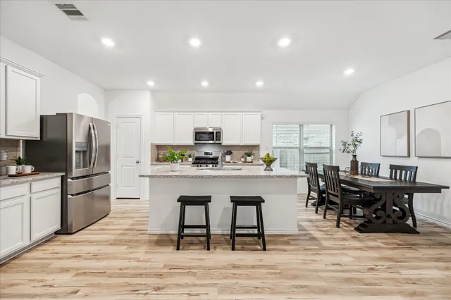 a kitchen with granite countertop a sink a counter top space and cabinets