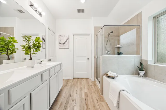a bathroom with a tub shower and sink