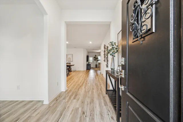 a view of a hallway with wooden floor and staircase