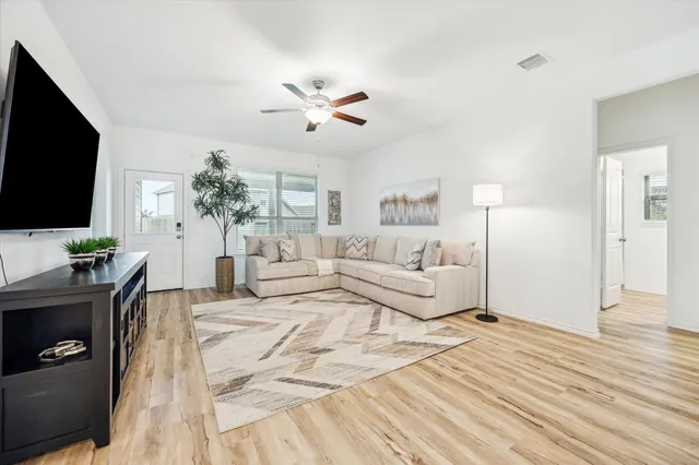 a living room with furniture a flat screen tv and a fireplace