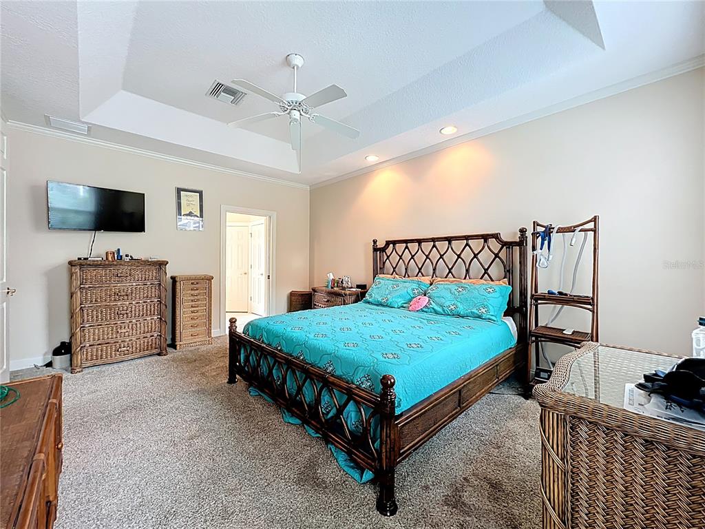 214 Chestnut Ridge Street Winter Springs, FL 32708 - Photo 33 of 68 a bedroom with a bed a flat screen tv and a fireplace