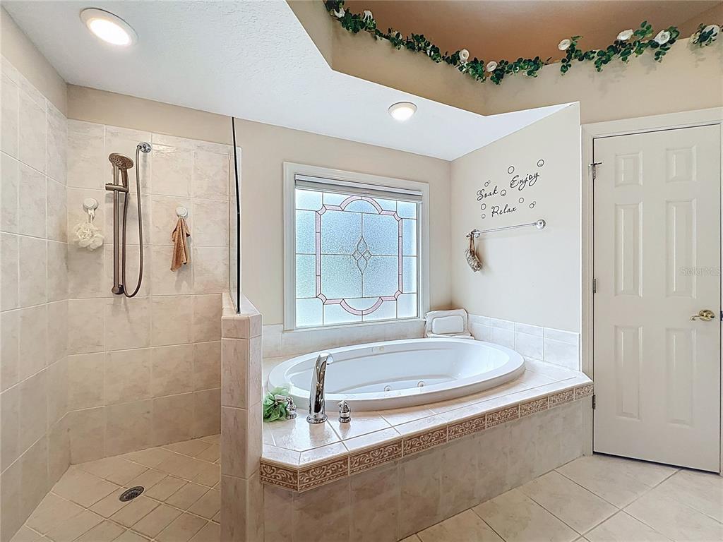 214 Chestnut Ridge Street Winter Springs, FL 32708 - Photo 39 of 68 a spacious bathroom with a tub shower and mirror