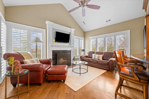a living room with furniture a flat screen tv and a large window
