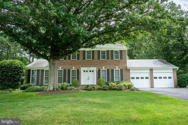 a front view of a house with a garden and trees