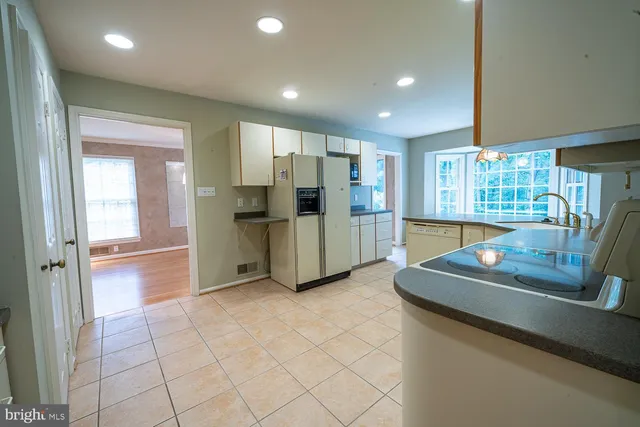 a kitchen with kitchen island granite countertop a sink counter top space appliances and cabinets