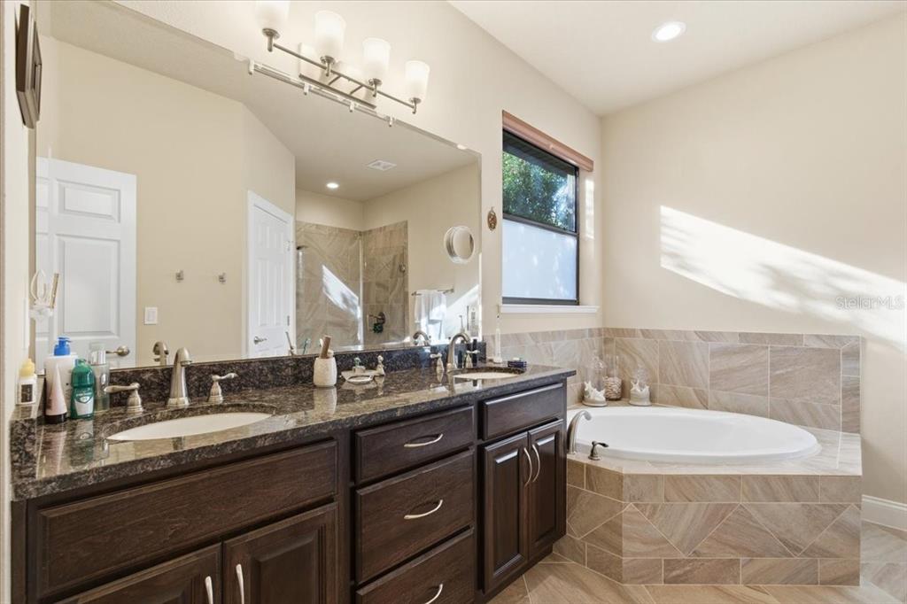 8 Cochran Lane Palm Coast, FL 32137 - Photo 22 of 40 a bathroom with a granite countertop sink mirror and bathtub