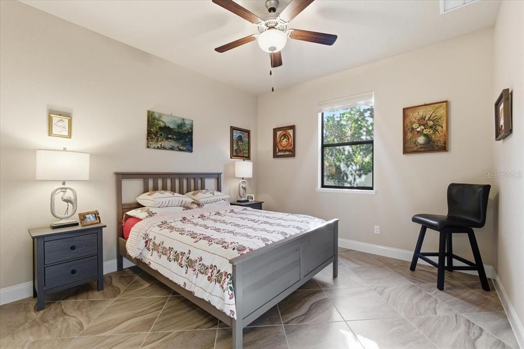 8 Cochran Lane Palm Coast, FL 32137 - Photo 29 of 40 a bedroom with a bed and a lamp on dresser with wooden floor