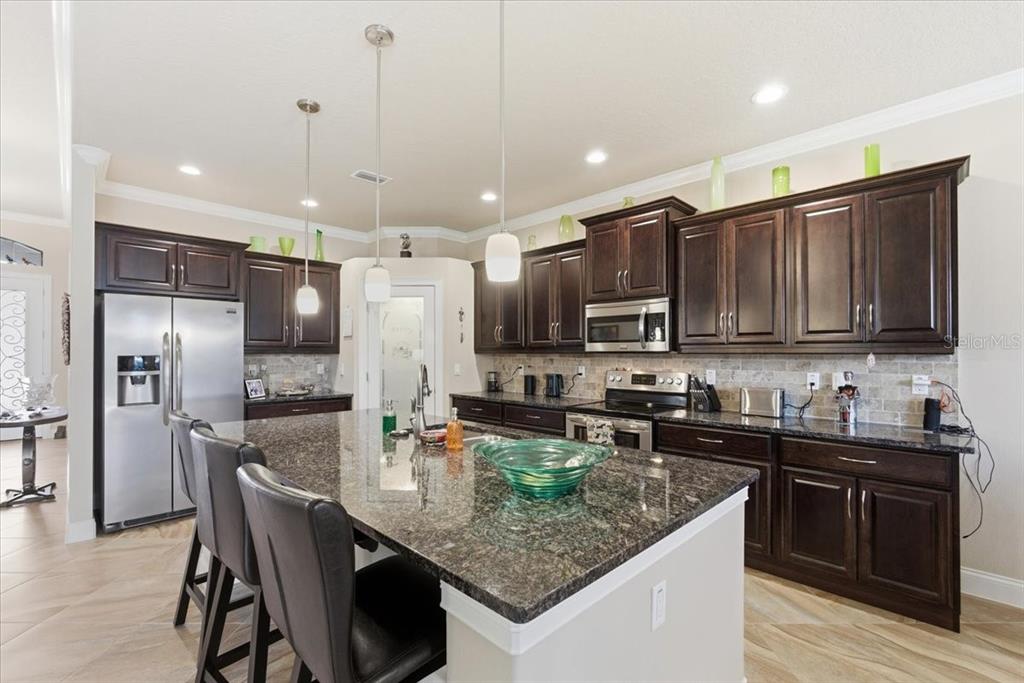 8 Cochran Lane Palm Coast, FL 32137 - Photo 8 of 40 a kitchen with stainless steel appliances granite countertop a sink a stove and refrigerator
