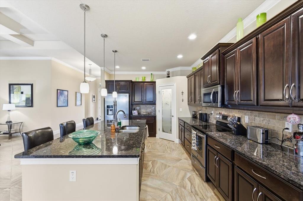 8 Cochran Lane Palm Coast, FL 32137 - Photo 9 of 40 a kitchen with stainless steel appliances granite countertop a sink a stove and a refrigerator