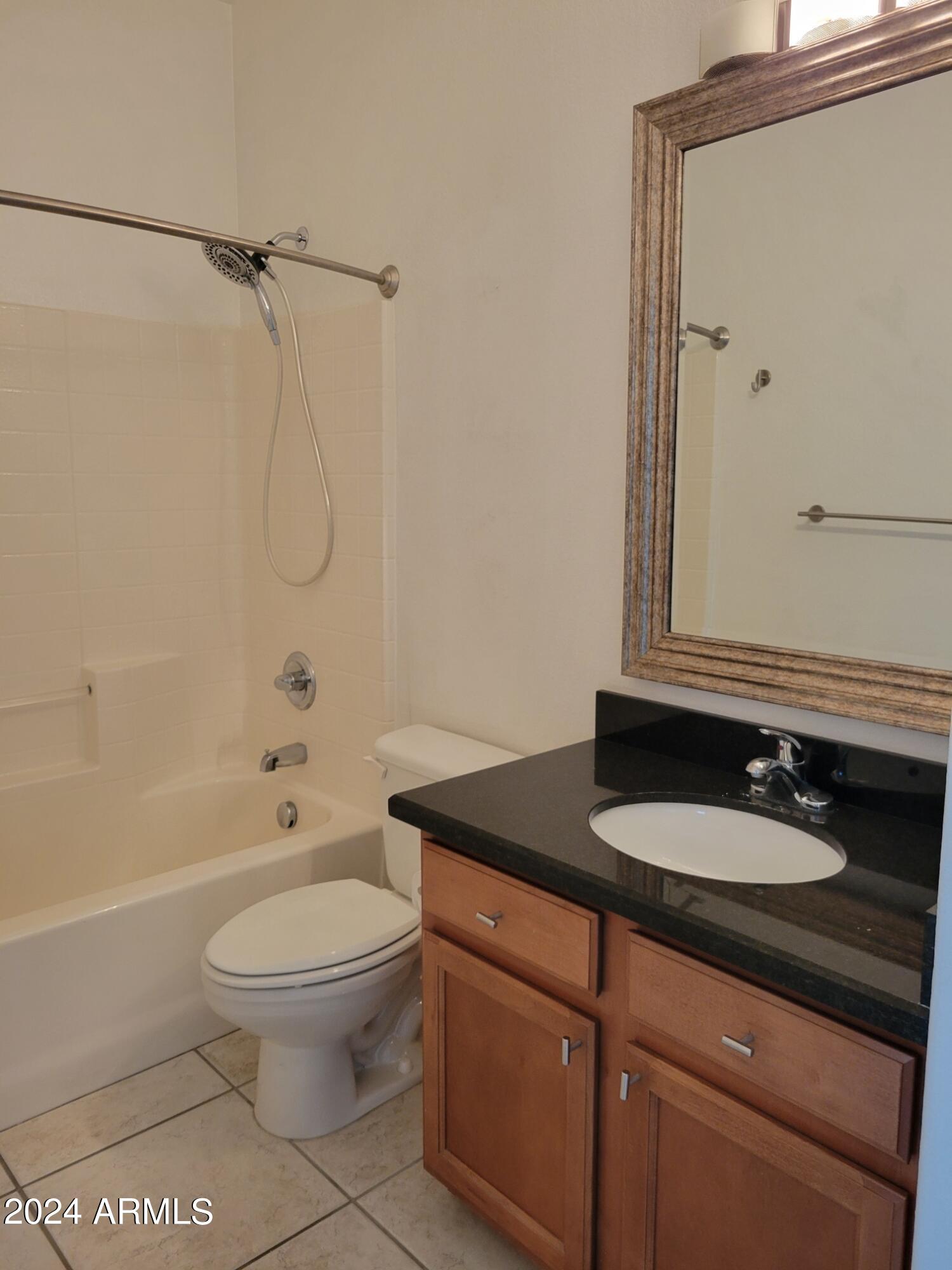 1886 East Don Carlos, Unit 164 Tempe, AZ 85281 - Photo 18 of 24 a bathroom with a granite countertop sink toilet a mirror and shower
