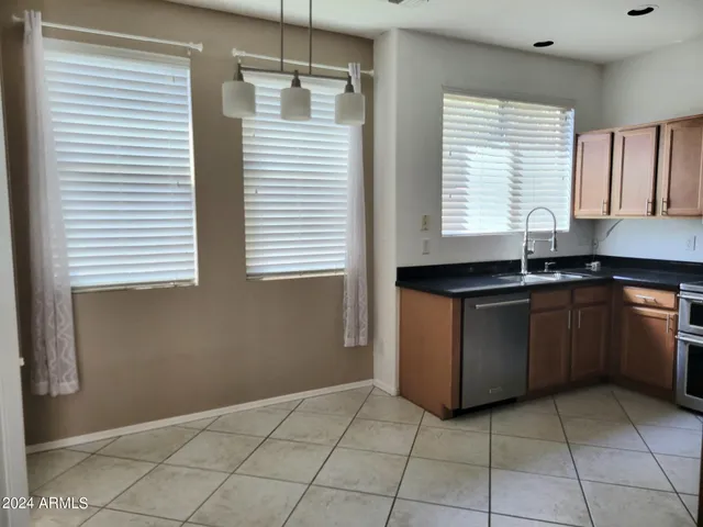 a kitchen with granite countertop a refrigerator stove and microwave