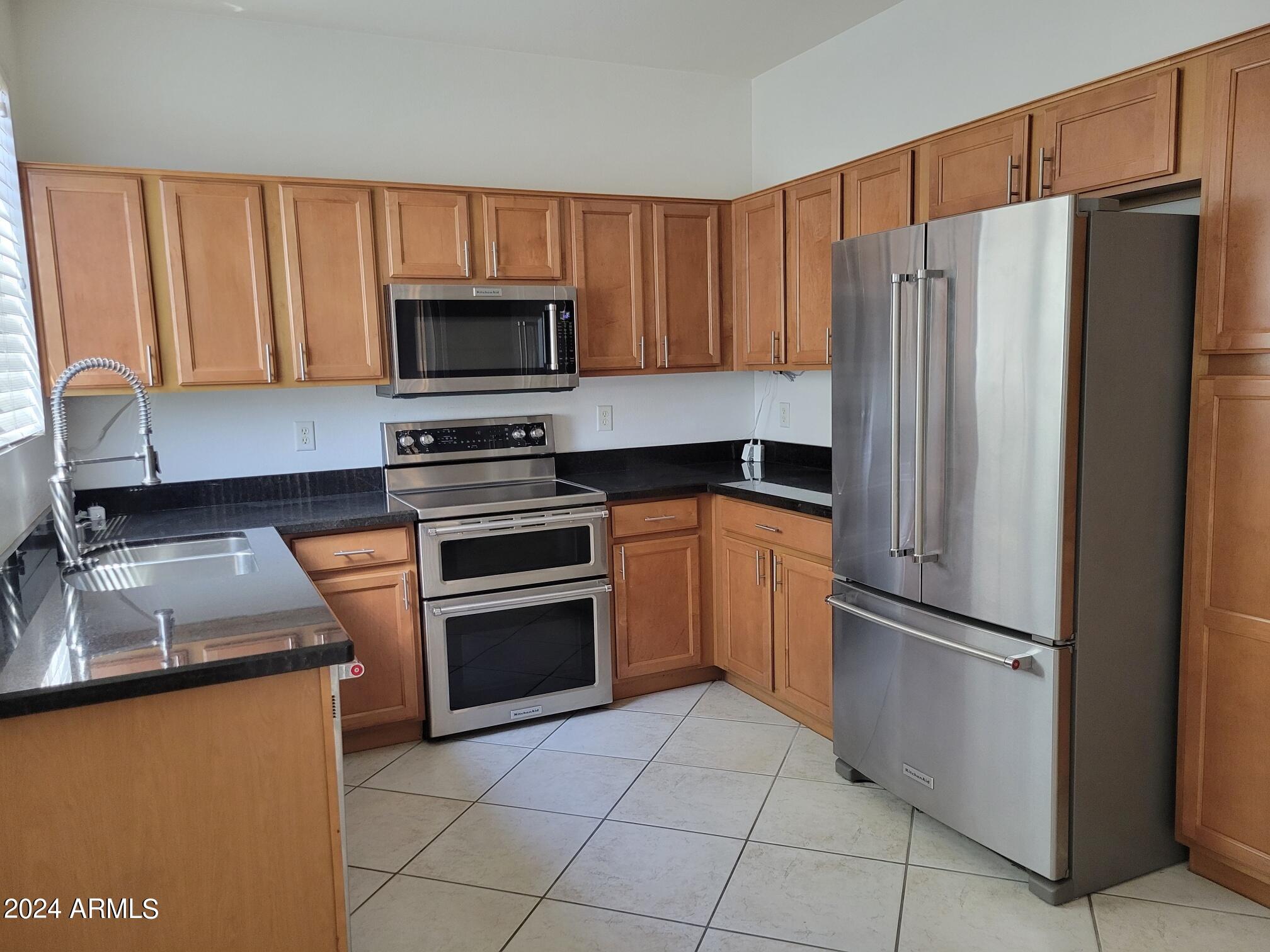 1886 East Don Carlos, Unit 164 Tempe, AZ 85281 - Photo 10 of 24 a kitchen with granite countertop a refrigerator stove and microwave