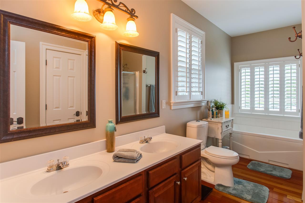 898 Turkey Ridge Road Stanardsville, VA 22973 - Photo 17 of 30 a bathroom with a granite countertop sink toilet a large mirror and a bathtub