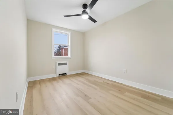 an empty room with a window and a ceiling fan