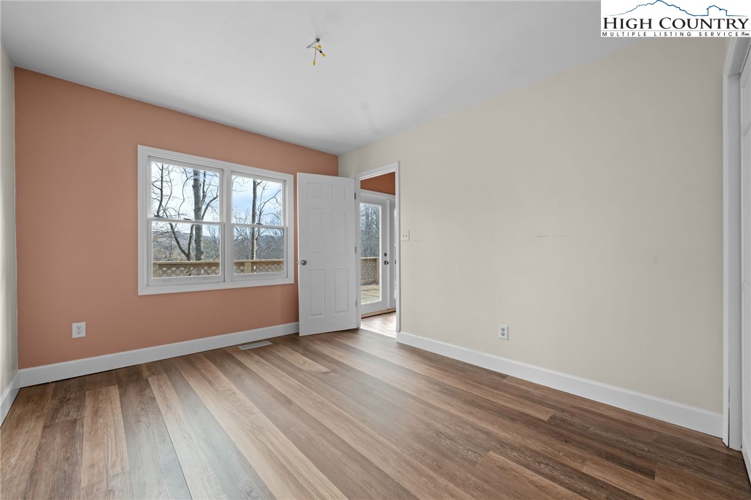 131 Hemlock Road Banner Elk, NC 28604 - Photo 11 of 37 an empty room with wooden floor and windows