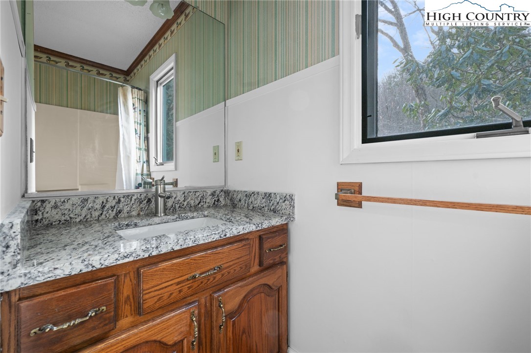 131 Hemlock Road Banner Elk, NC 28604 - Photo 18 of 37 a bathroom with a granite countertop sink and a mirror