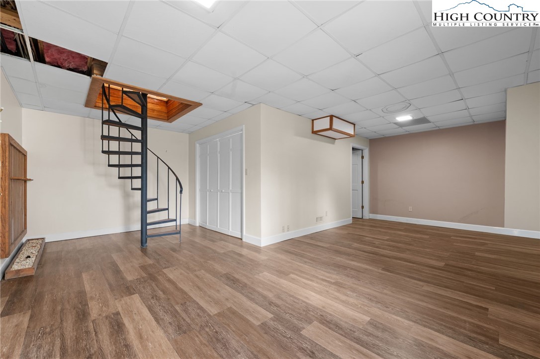 131 Hemlock Road Banner Elk, NC 28604 - Photo 22 of 37 a view of an empty room with wooden floor and stairs