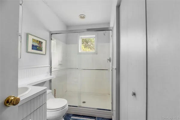 a bathroom with a granite countertop sink a toilet and shower