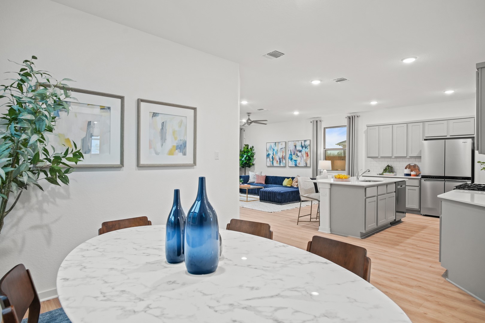 190 Hornet Street Elgin, TX 78621 - Photo 15 of 40 a kitchen with stainless steel appliances granite countertop a refrigerator a stove a sink dishwasher and white cabinets with wooden floor