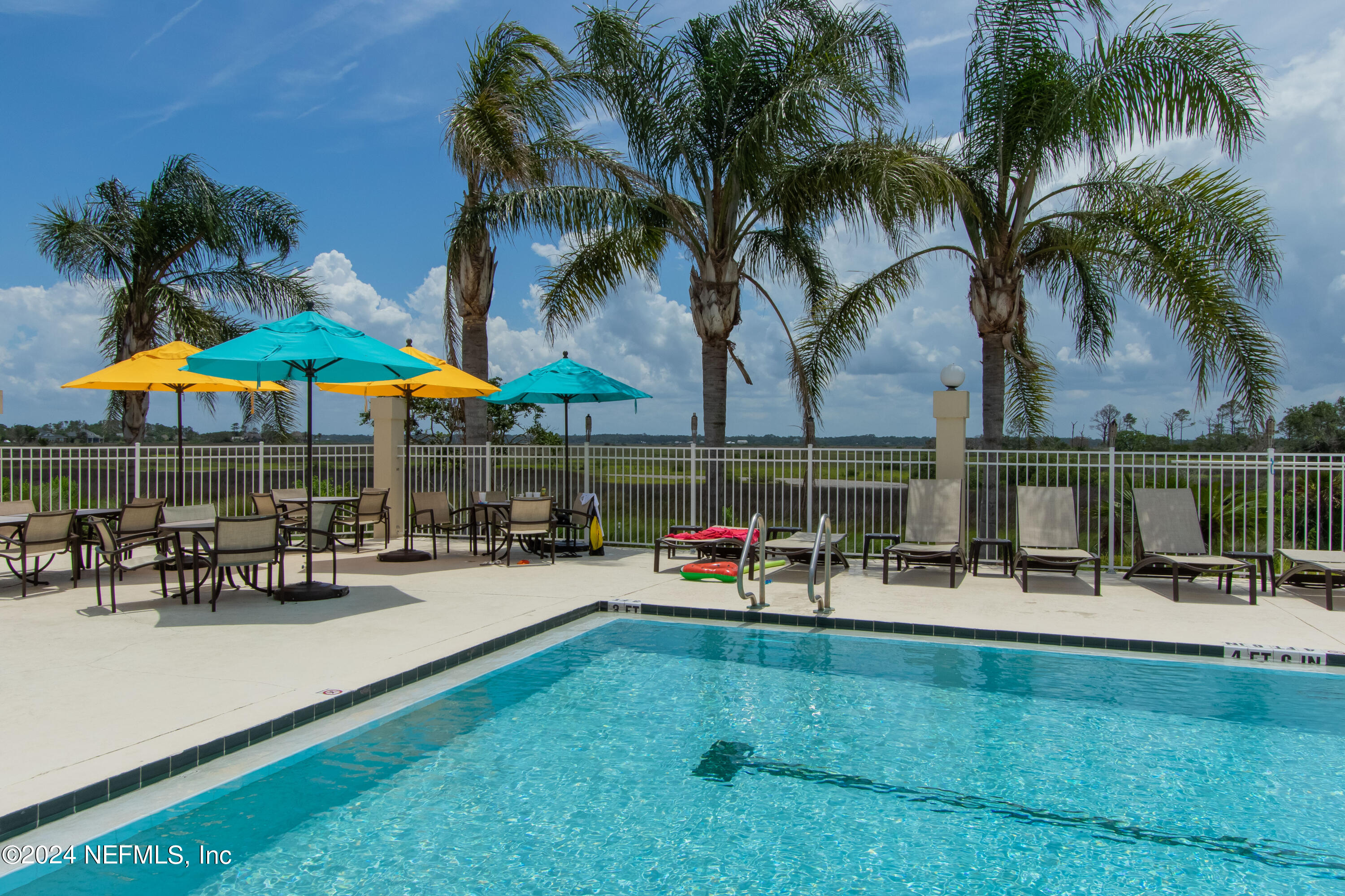 348 Fiddlers Point Drive St. Augustine, FL 32080 - Photo 56 of 58 a couple of table and chairs under an umbrella in front of house