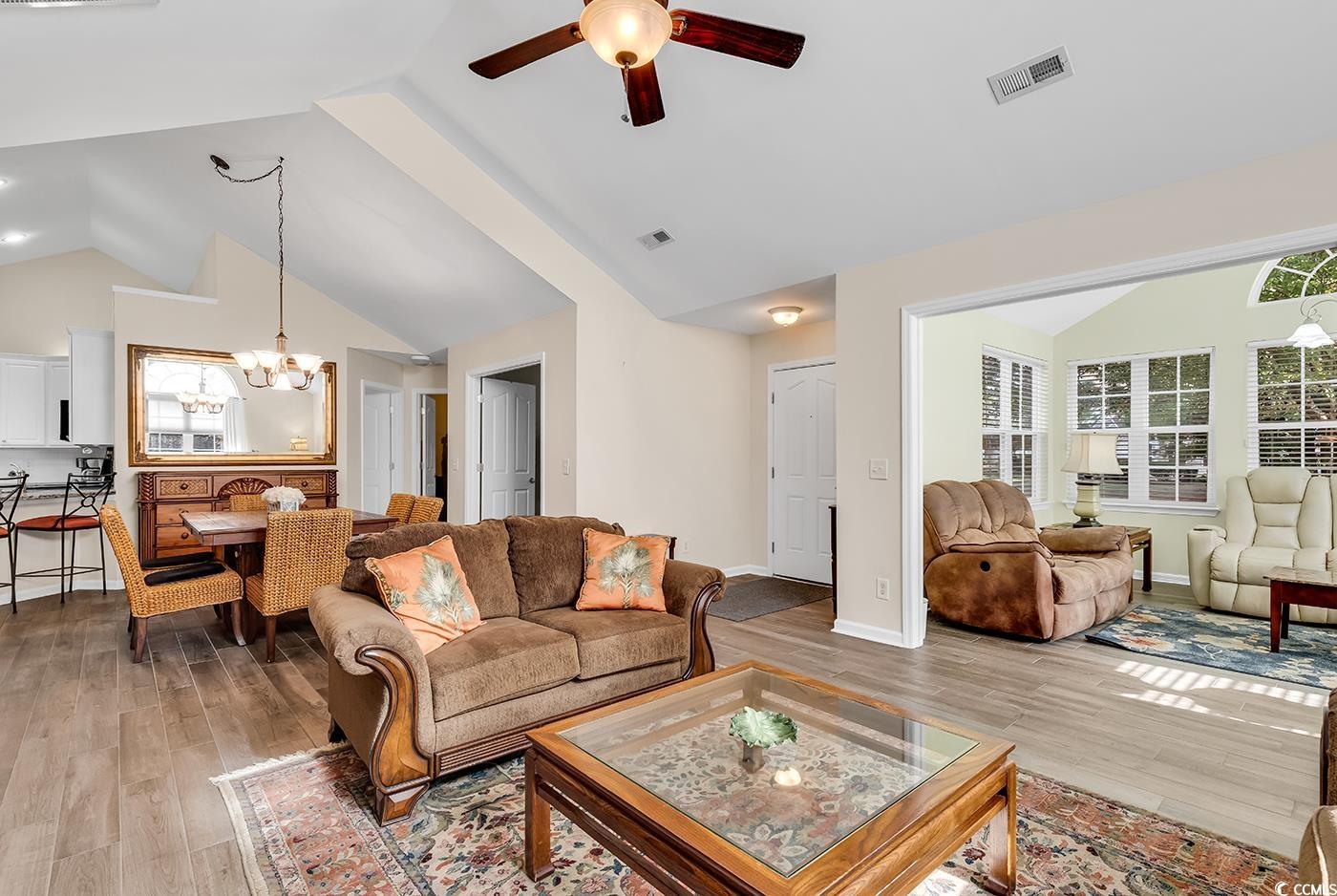 145 Stonegate Boulevard, Unit 145 Murrells Inlet, SC 29576 - Photo 3 of 40 Living room featuring high vaulted ceiling, ceiling fan with notable chandelier, and light wood-type flooring