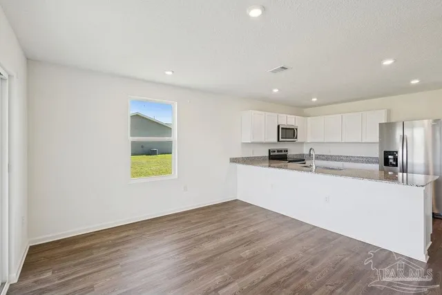 a kitchen with a refrigerator and a stove top oven