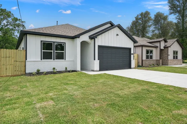 a front view of a house with a garden and yard