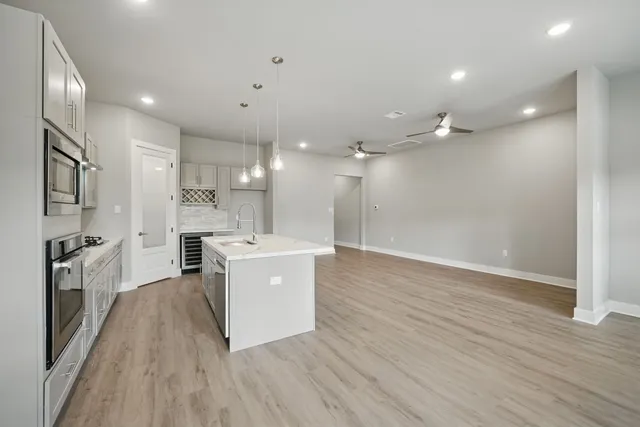 a large kitchen with a sink and stainless steel appliances