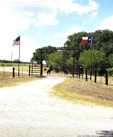 a view of a swimming pool with a lawn chairs and iron fence