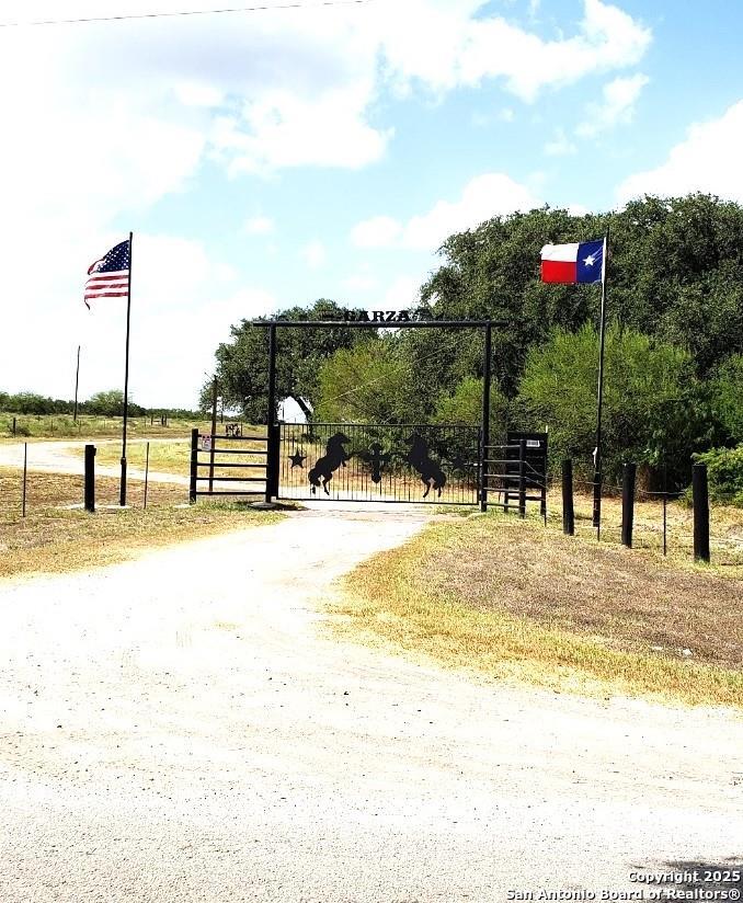 a view of a swimming pool with a lawn chairs and iron fence