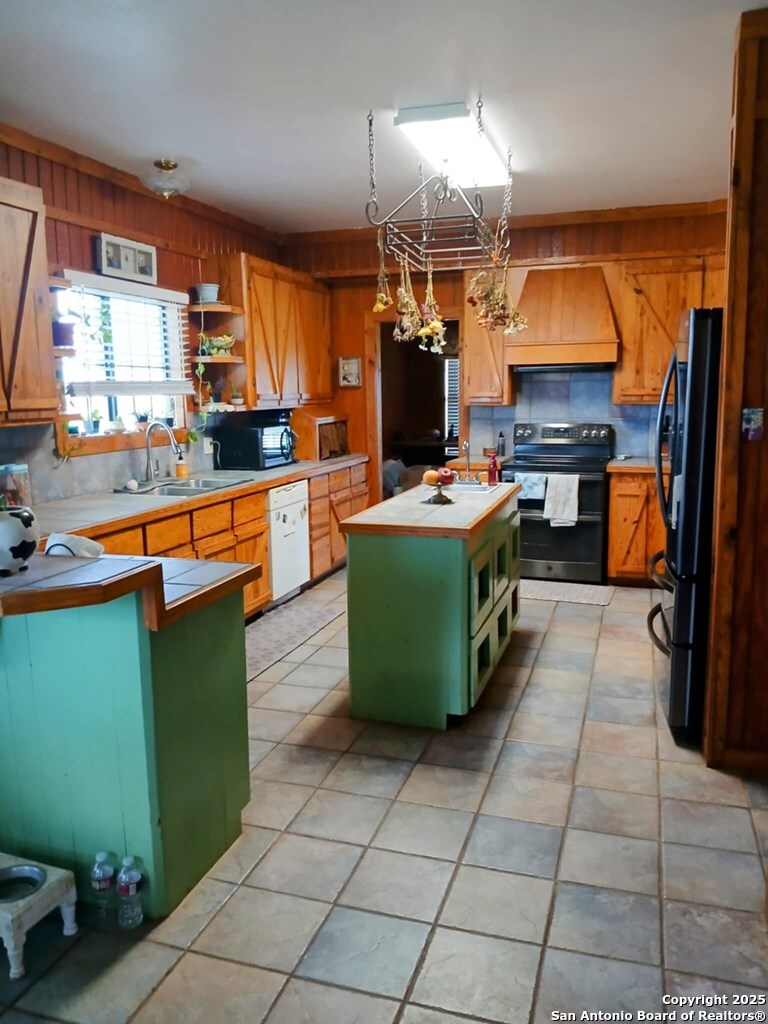 1121 Colony Road Beeville, TX 78102 - Photo 15 of 19 a kitchen with kitchen island a stove top oven a sink and a refrigerator
