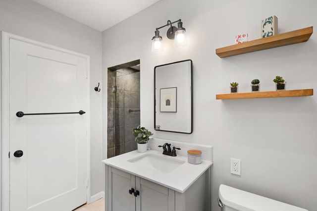 a bathroom with a sink a toilet and shower