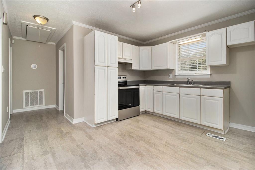 150 Dub Walker Road Jackson, GA 30233 - Photo 12 of 32 a kitchen with stainless steel appliances granite countertop a stove a sink dishwasher a refrigerator and white cabinets with wooden floor