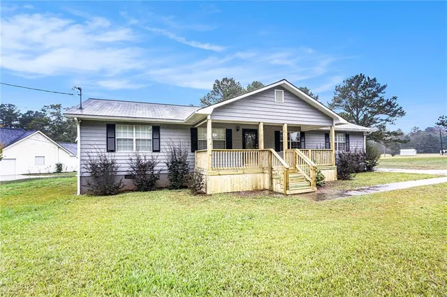 a view of a house with a big yard and large tree